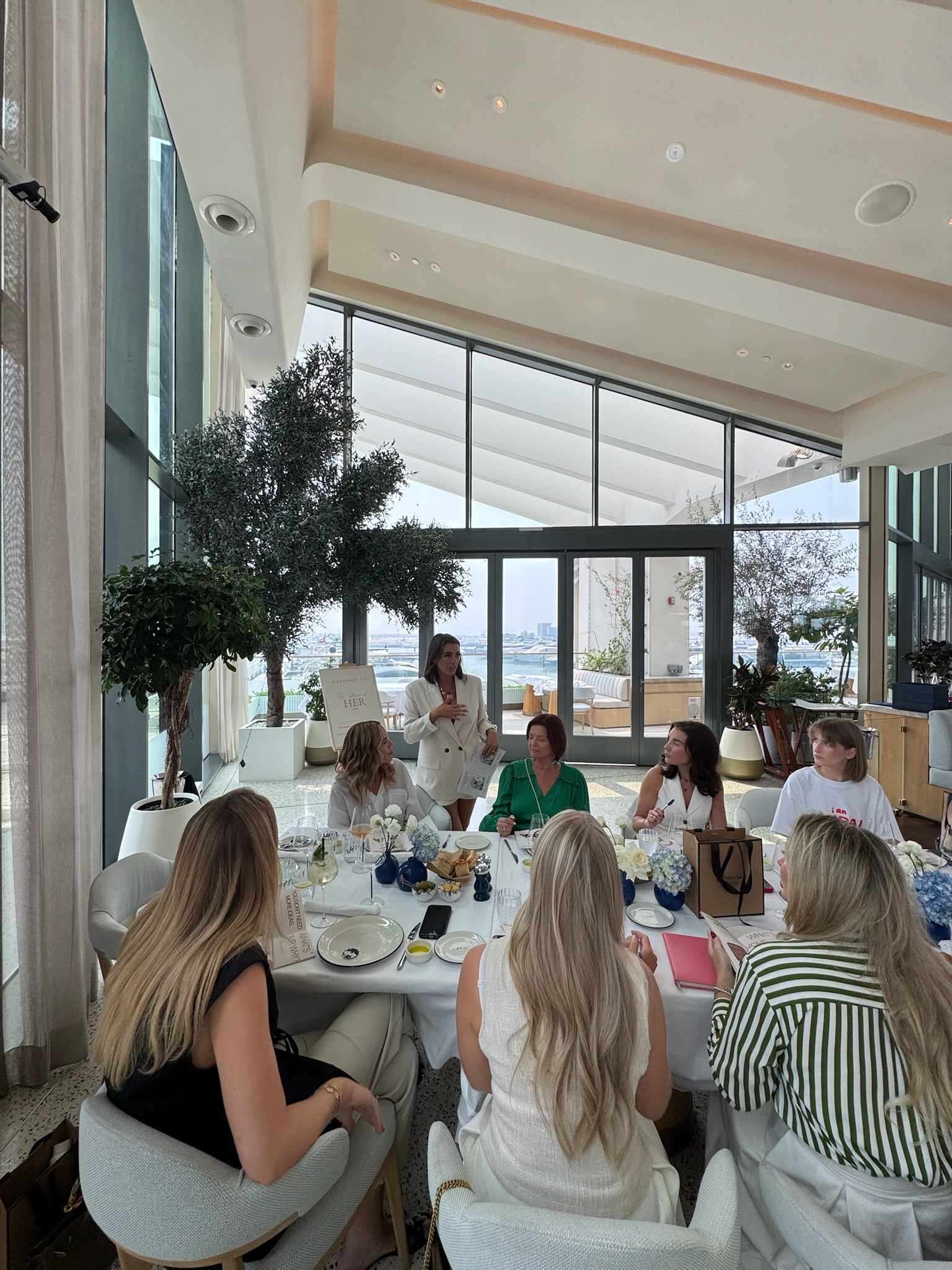 Amy speaking to founders seated around the workshop table at House of Her